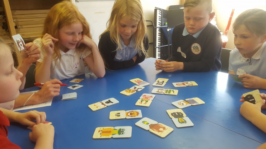 Group of children around a table playing a matching game