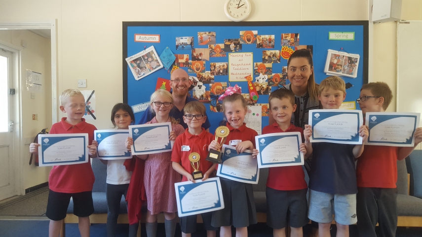 Eight children with their teacher and an Imagination Gaming staff member, all holding certificates