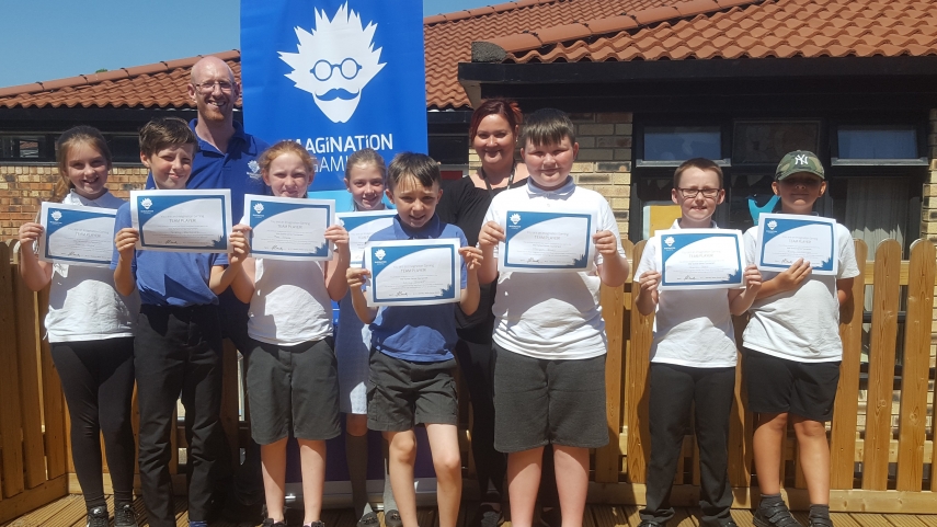 A group of children with certificates and Imagination Gaming staff