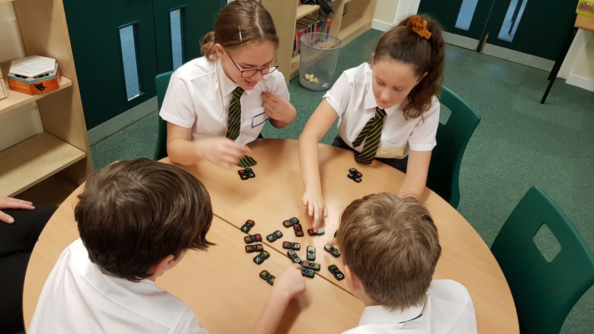 Children playing a dominoes based game on a table