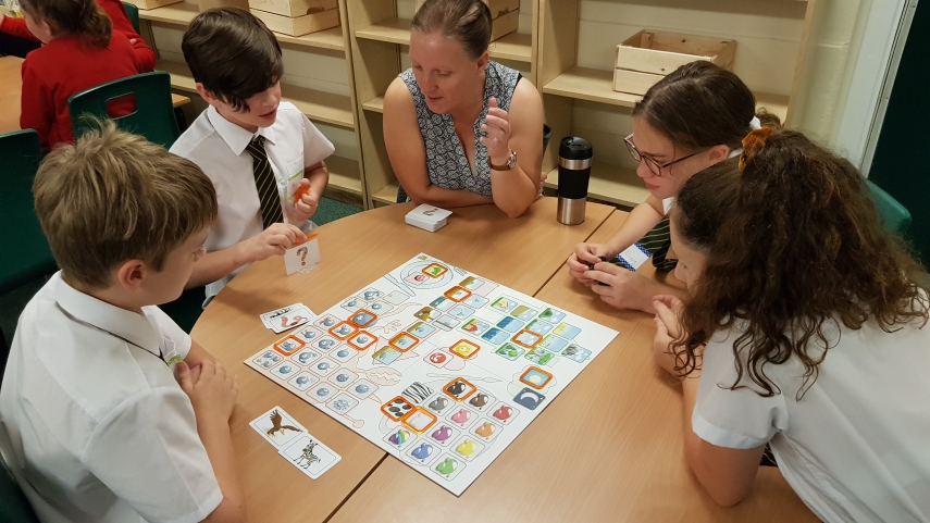 Teacher and pupils playing a board game