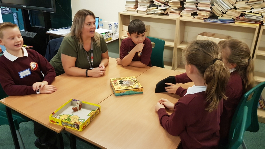 Teacher and pupils discussing how to play a board game