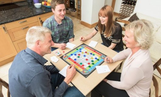 Family sat around a table playing Jask