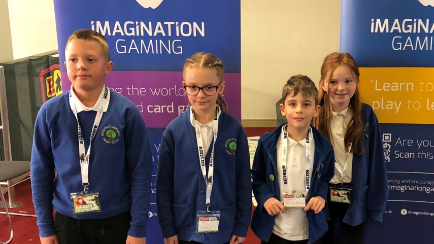 Four children stood in front of Imagination Gaming banners