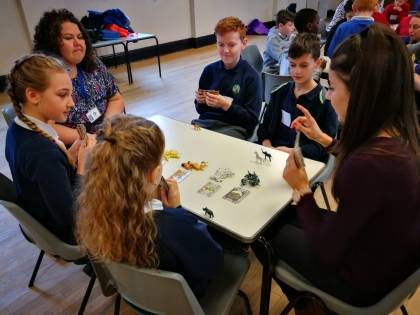 Staff and pupils sat around a table playing card games