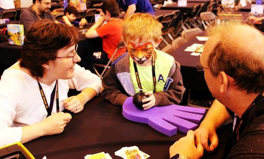 Child playing a game with two adults