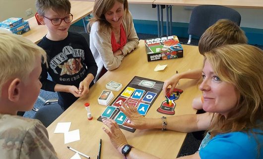 Children and adults playing Word Rush board game