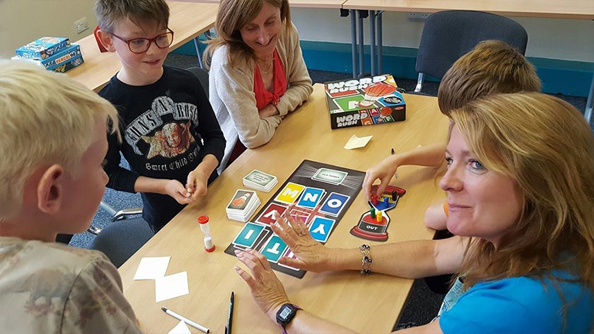 Children and adults playing Word Rush board game